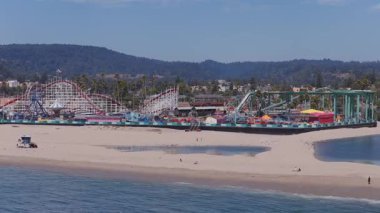 Kaliforniya 'da Santa Cruz sahil şeridi manzaralı. Dev Ayı Lunaparkı lunapark treni, renkli araçlar, atlıkarınca ve kumsala bakan kumsal manzaralı..