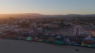 Gün batımında Santa Cruz, California 'nın havadan görünüşü, Sahil Sahili Boardwalk, Dev Ayı Lunaparkı lunapark treni, sahil ve hareketli şehir.