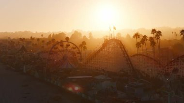Günbatımında Santa Cruz, California 'nın havadan görünüşü. Dev Ayı rollercoaster, dalgalanan Amerikan bayrakları, palmiye ağaçları ve arka planda yuvarlanan tepeler. GTA biçimi.