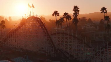 Günbatımında Santa Cruz, California 'nın havadan görünüşü. Giant Dipper lunapark treni, dönme dolap, palmiye ağaçları ve geniş bir panorama..