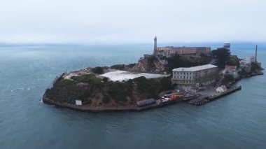 San Francisco Körfezi 'ndeki Alcatraz Adası' nın havadan görünüşü. Cezaevi, deniz feneri, su kulesi ve okyanus yavaş hareket ediyor..