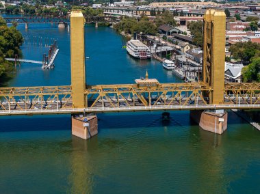 Altın Kule Köprüsü, Sacramento Nehri 'ni rıhtımları, tekneleri, nehir kenarındaki binaları, yeşillikleri ve uzak mesafeden görülebilen köprüleri ile geçer..