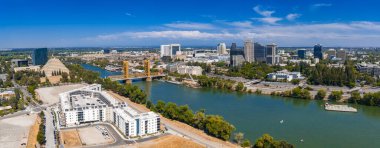 Sacramento, California 'nın havadan görünüşü, Sacramento Nehri üzerindeki Tower Köprüsü, şehir merkezindeki yüksek binalar, Eyalet Kongre Binası ve yemyeşil alanlar..