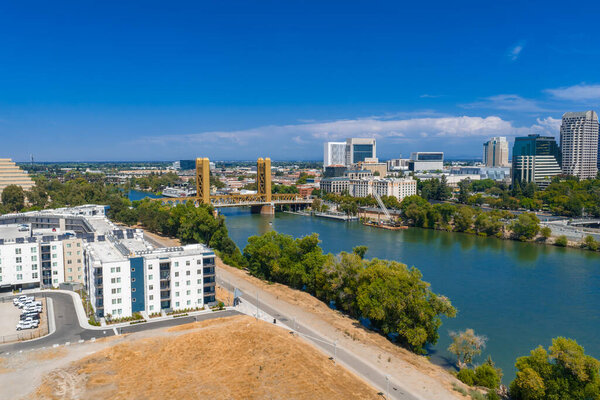 Вид с воздуха на Сакраменто, Калифорния, с золотым Тауэрским мостом через реку Сакраменто, горизонтом города и Капитолием штата вдалеке.