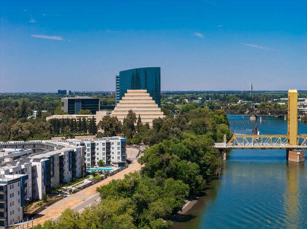 Вид с воздуха на Сакраменто, Калифорния, показывающий Тауэрский мост, Зиггурат, современные здания, зеленые насаждения и чистое голубое небо.