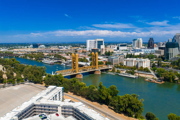 Вид с воздуха на Сакраменто, Калифорния, с золотым мостом через реку Сакраменто, высотные здания в центре города и здание Капитолия штата.