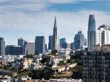 San Francisco şehir merkezi Transamerica Piramidi, Salesforce Kulesi, konut binaları, yeşillik ve bulutlu açık mavi gökyüzü..
