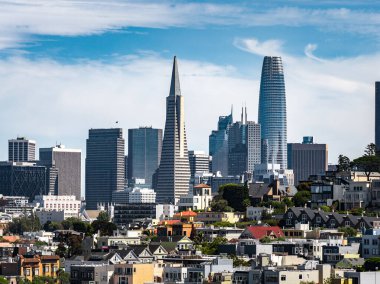 San Francisco şehir merkezindeki Transamerica Piramidi, Satış Kulesi ve Viktorya dönemi tarzı evler açık mavi gökyüzü altında yer alıyor..