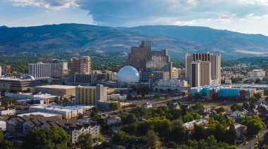 Reno, Nevada şehir merkezinin hava manzarası, Silver Legacy Resort Casino, yüksek binalar, yerleşim alanları, ve Sierra Nevada dağları.
