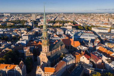 Riga, Letonya 'nın havadan görünüşü, St. Peter Kilisesi kulesinin sergilenmesi, tarihi eski şehrin kırmızı kiremitli çatıları, modern binalar, ve yeşil alanlar.