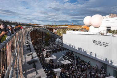 Ziyaretçiler Belçika Pavyonu 'nda modern mimari ve yeşilliklerle çevrili çatı katı, harita ve yüksek yürüyüş yolları ile bir araya geldiler..