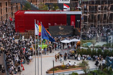 Ziyaretçiler, Kore Pavyonu, ulusal bayraklar, aynalı mimari, yeşillik ve oturma alanlarının yer aldığı Osaka, Japonya 'daki 2025 Dünya Fuarı' nı keşfediyorlar..