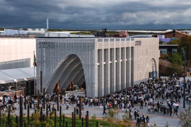 Osaka 'daki 2025 Dünya Fuarı' ndaki Azerbaycan Pavyonu 'nda karmaşık kafesler, kemerli girişler ve arka planda yeşillik bulunan Azerbaycan bayrağı yer alıyor..