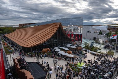 Dünya Fuarı 2025 Osaka 'da, dalgalı bir terracotta çatısı, aynalı bir bina, gerçek boyutta fil heykelleri ve uluslararası bayrakları bulunan ziyaretçiler bir araya geldiler..