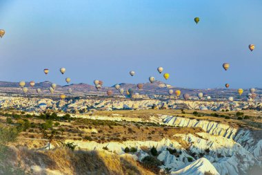 Renkli sıcak hava balonları, sabah güneşi doğarken Cappadocias 'ın yukarısındaki gökyüzünü eşsiz kaya oluşumlarıyla doldurarak nefes kesici bir macera ve güzellik manzarası yaratıyor..