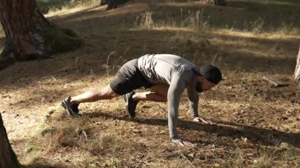 胸に足でプランクロード 自然の森の中でスポーツ スローモーション — ストック動画