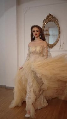 Uzun trenli, şenlikli bir elbise giymiş güzel bir genç kız Noel ağacının yanında.