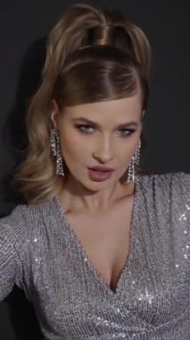 Genç bir kadın kulübün neon ışığında kameraya bakıyor. Güzel, fütürist bir kızın yakın plan portresi. Çok renkli parlayan bir bayan. Baştan çıkarıcı bakışlı bir kız.