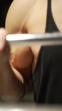 Vücut geliştirici spor salonunda pazı egzersizi yapıyor. Seksi vücudunu geliştiriyor.