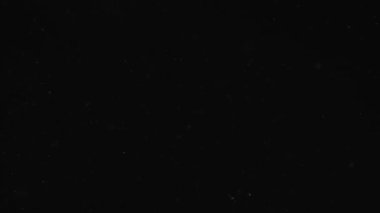 Siyah karanlıkta beyaz peri tozunun hareketi