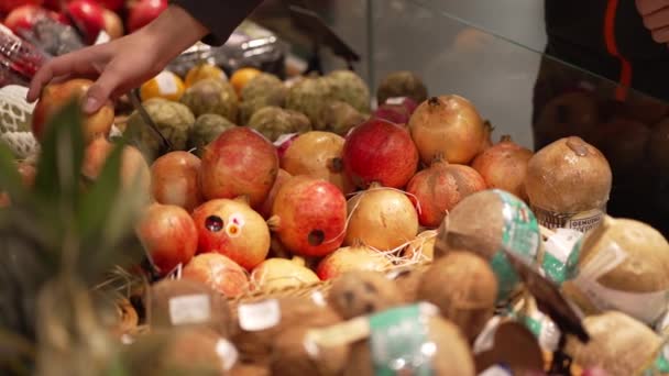スーパーで新鮮なザクロを選ぶ男性の手 ベジタリアン ビーガンの自然食品 — ストック動画