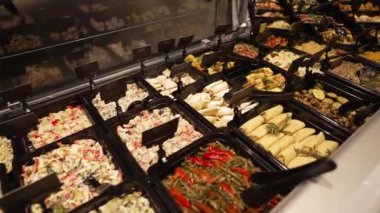 Tezgahtaki metal kaplarda hazır yemeklerden oluşan geniş bir çeşitlilik. Yemek servisi.