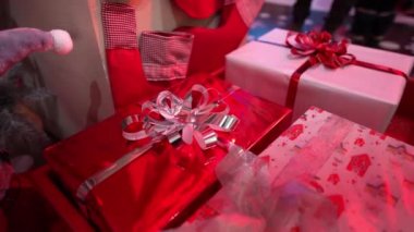 Kırmızı ambalaj kağıdına sarılı Noel hediyesi, şenlikli parlak gümüş kurdele. Yeni yıl hediyeleri.