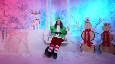 Bir peri perisi Noel Baba 'nın evinde salıncakta sallanıyor.