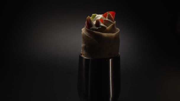シャワルマやドナーケバブ黒の背景に移動します トマト 玉ねぎ レタスで作られたシャワルマは ピタパンに包まれ 白いソースで注がれます — ストック動画
