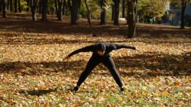 Sporcu vücudun esnekliği için egzersiz yapar. Sonbahar şehri ve park