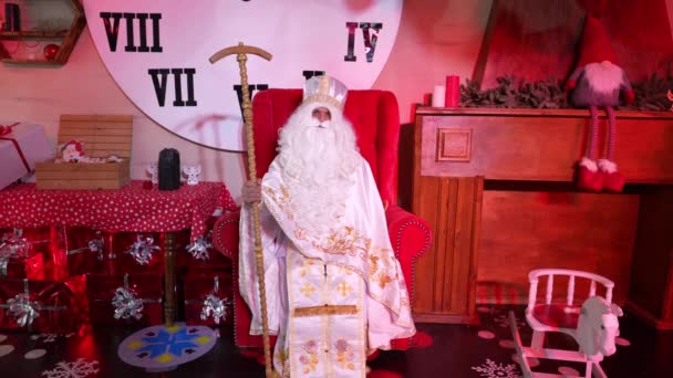 Пенсионер Санта Клаус Сидит Удобном Кресле Возле Елки Множеством Подарков — стоковое видео
