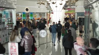 A modern shopping center with consumers walking and buying a variety of goods