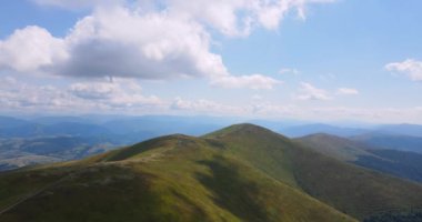 Dağların üzerinde beyaz bulutlar yoğunlaşıyor. Yüksek kalite 4k görüntü