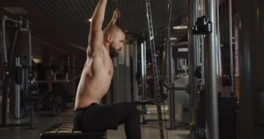 Professional athlete doing barbell training in the gym. A muscular and athletic bodybuilder is doing an exercise with a barbell.