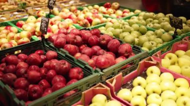 Organic apples are displayed for sale and sorted by containers
