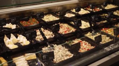 Food preparation, portions of ready-made food laid out in a supermarket window. The sale of ready-made meals is carried out in a store, a cold showcase for storing and selling products.