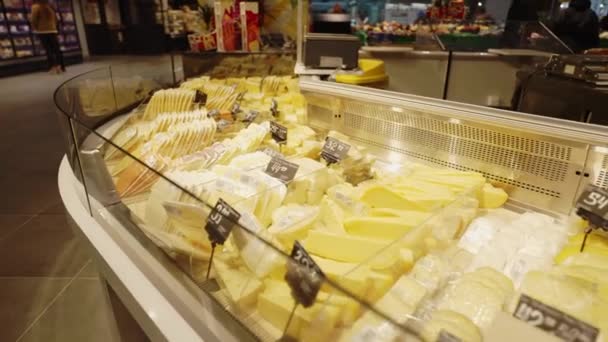在商店的陈列柜上放有价签的各种切碎的奶酪片 有奶酪的窗户 超市里的奶酪部门 商场的食品部 乳制品 — 图库视频影像