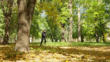 A young attractive man is jogging in the afternoon in an autumn park