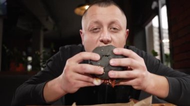 A young man eats fast food in a restaurant