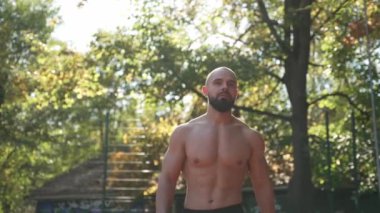 Şehir parkında yakışıklı, kaslı, üstsüz, seksi adam.