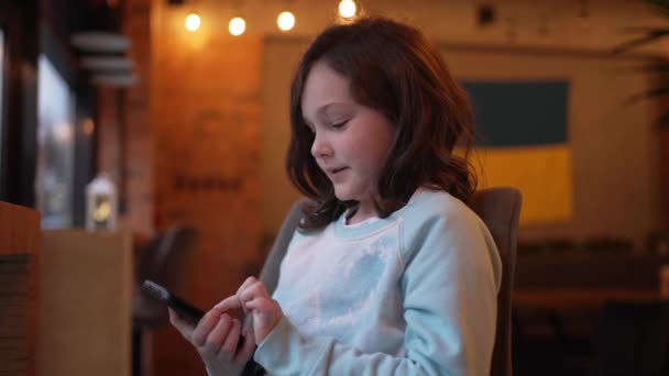 Seorang Gadis Ukraina Kecil Membaca Pesan Teks Telepon Dan Tersenyum — Stok Video