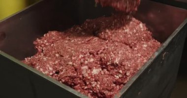 Industrial cutter with minced pork meat inside. Metal construction filled with grinded processed meat. Sausage farm. Meat production place.