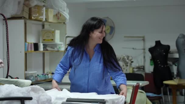 Μια Γυναίκα Ράφτης Απλώνει Ύφασμα Ένα Τραπέζι Στο Εργαστήριο Και — Αρχείο Βίντεο