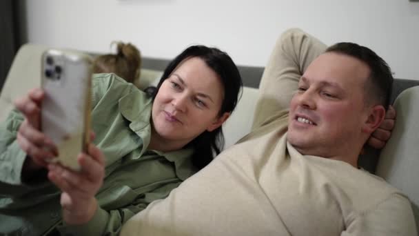 Чоловік Дружина Лежать Дивані Вдома Спілкуються Онлайн Друзями Мобільному Телефоні — стокове відео