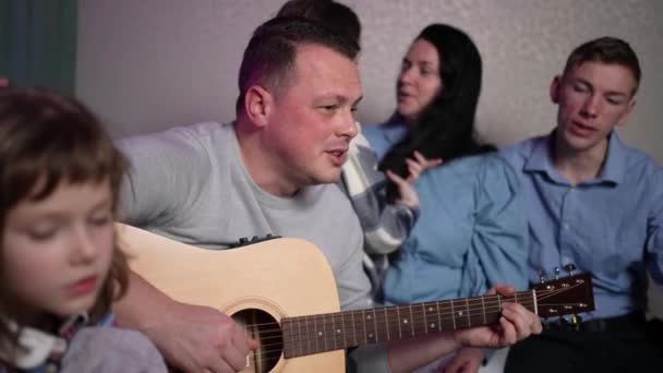 Adult Man Sings Song Plays Guitar His Family Sitting Couch — Vídeo de Stock