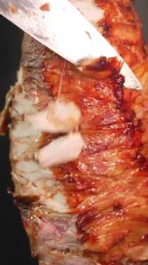 Aşçının elleri eti dikey olarak elektrikli ısıtıcıyla doğruyor keskin bıçaklarla donör kebabı ya da pita ekmeğinde shawarma hazırlıyor. Bir parça sulu tavuk veya domuz eti.