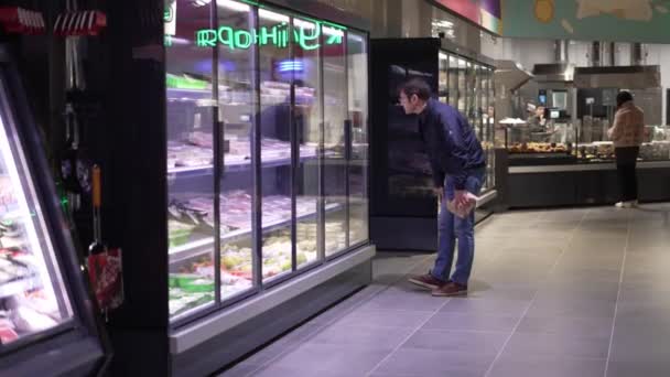 Man Chooses Products Supermarket Looks Window Reads Labels — Stock Video