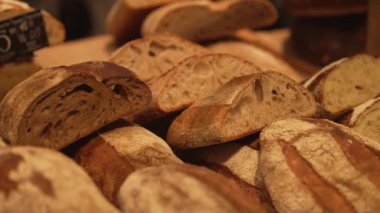 Loaves of rye farm bread lie on the wooden bakery shelf. Close-up shot