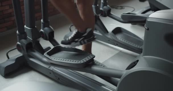 男はジムのトレッドミルで働いている 心臓トレーニング 足の筋肉をポンピング — ストック動画