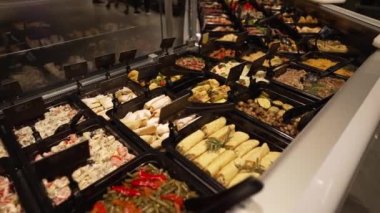 Food preparation, portions of ready-made food laid out in a supermarket window. The sale of ready-made meals is carried out in a store, a cold showcase for storing and selling products.